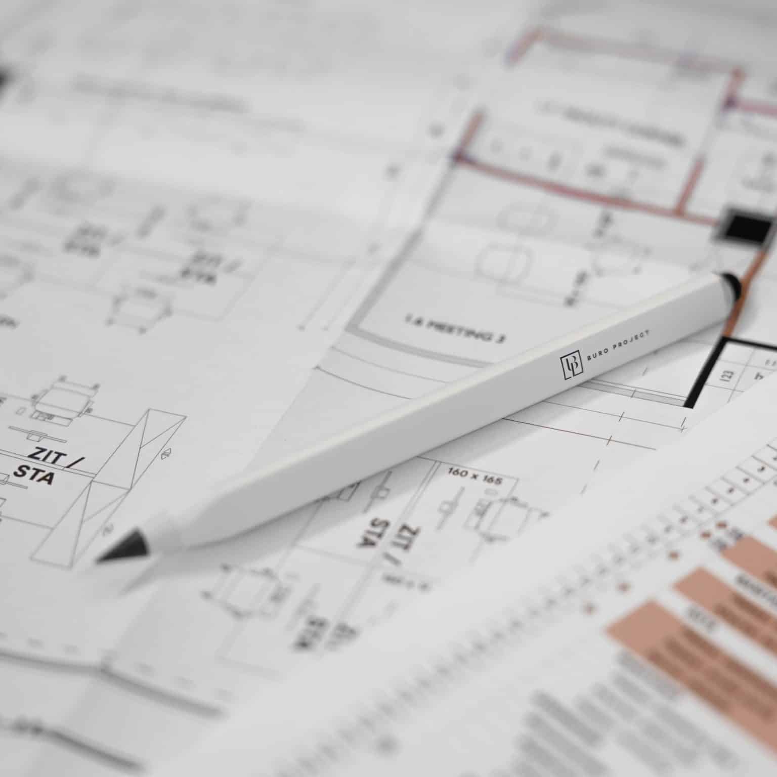 Technische bouwplannen met een pen gebruikt voor de coördinatie van een coworkingproject