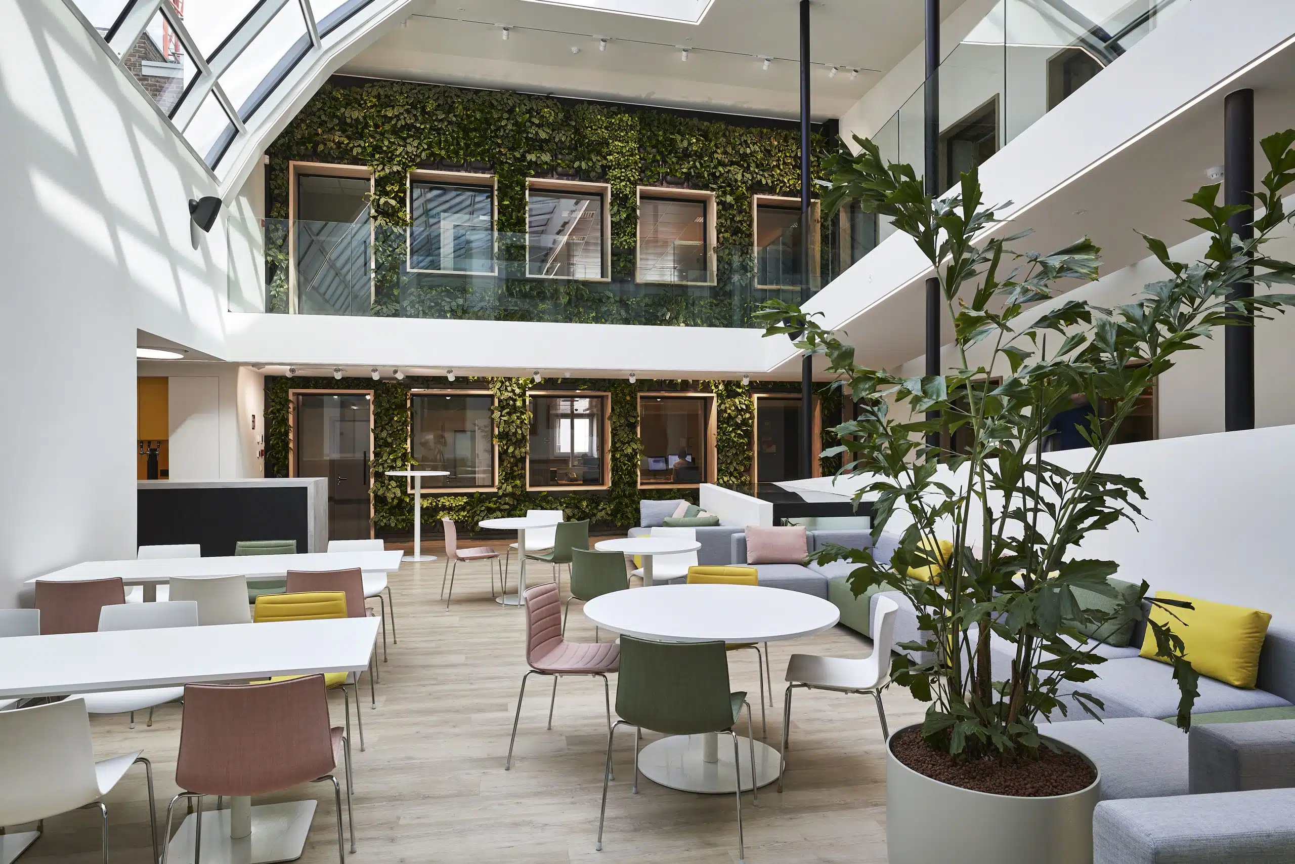 Open kantoorruimte met groene wand en kleurrijk meubilair voor een inspirerende sfeer