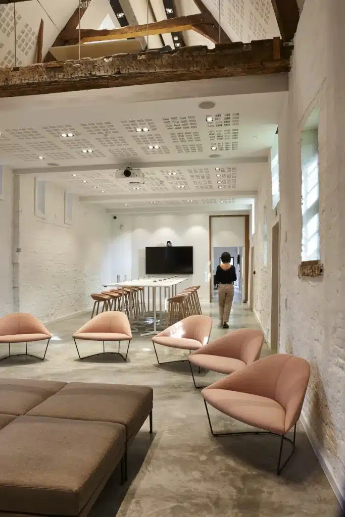 Flexibele onderwijsruimte met moderne zitstoelen, hoge tafels en zichtbare houten balken