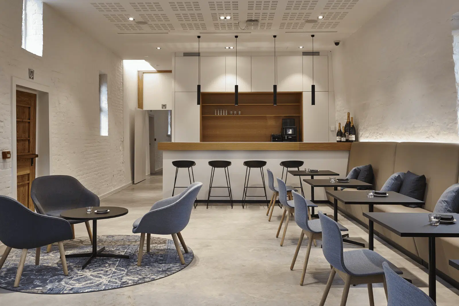 Gezellige meet&eat ruimte met bar, blauwe stoelen en warme verlichting