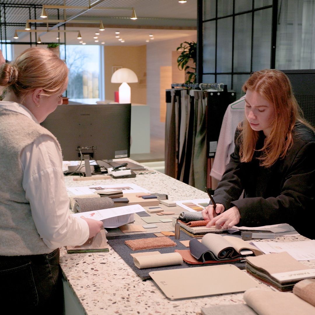 Interieurontwerpers bespreken materialen en kleuren voor een inrichting van een directiekantoor
