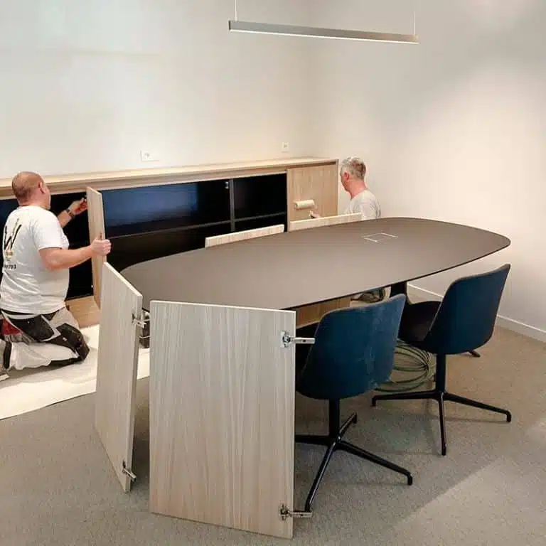 Monteurs plaatsen het laatste meubilair tijdens de oplevering van een nieuw kantoor