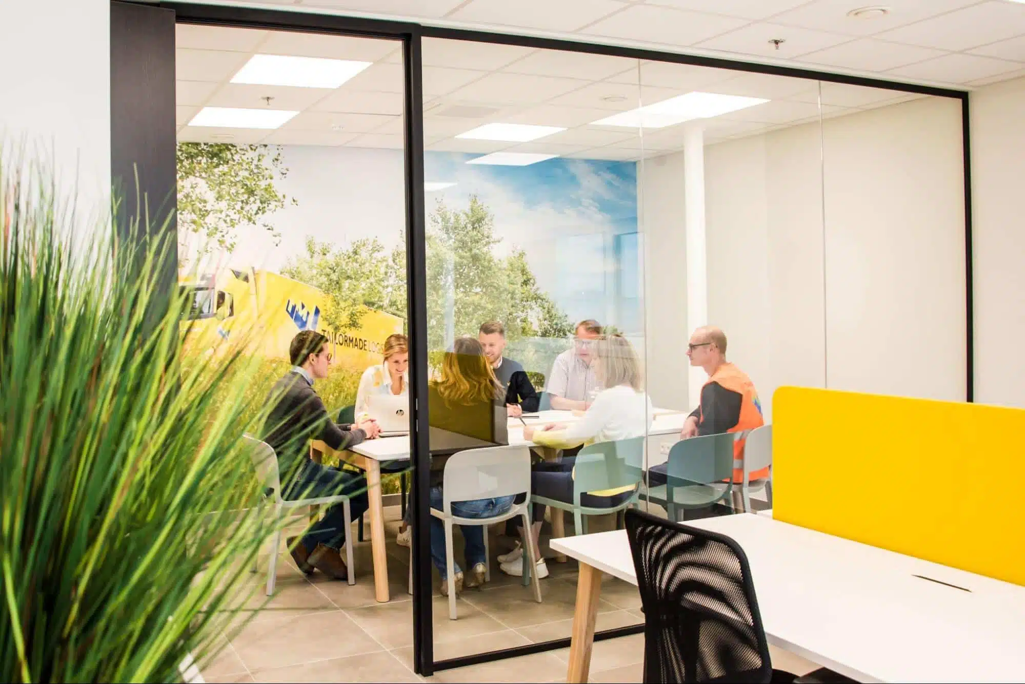 Vergaderruimte met glazen wanden en teamoverleg bij een logistieke klant