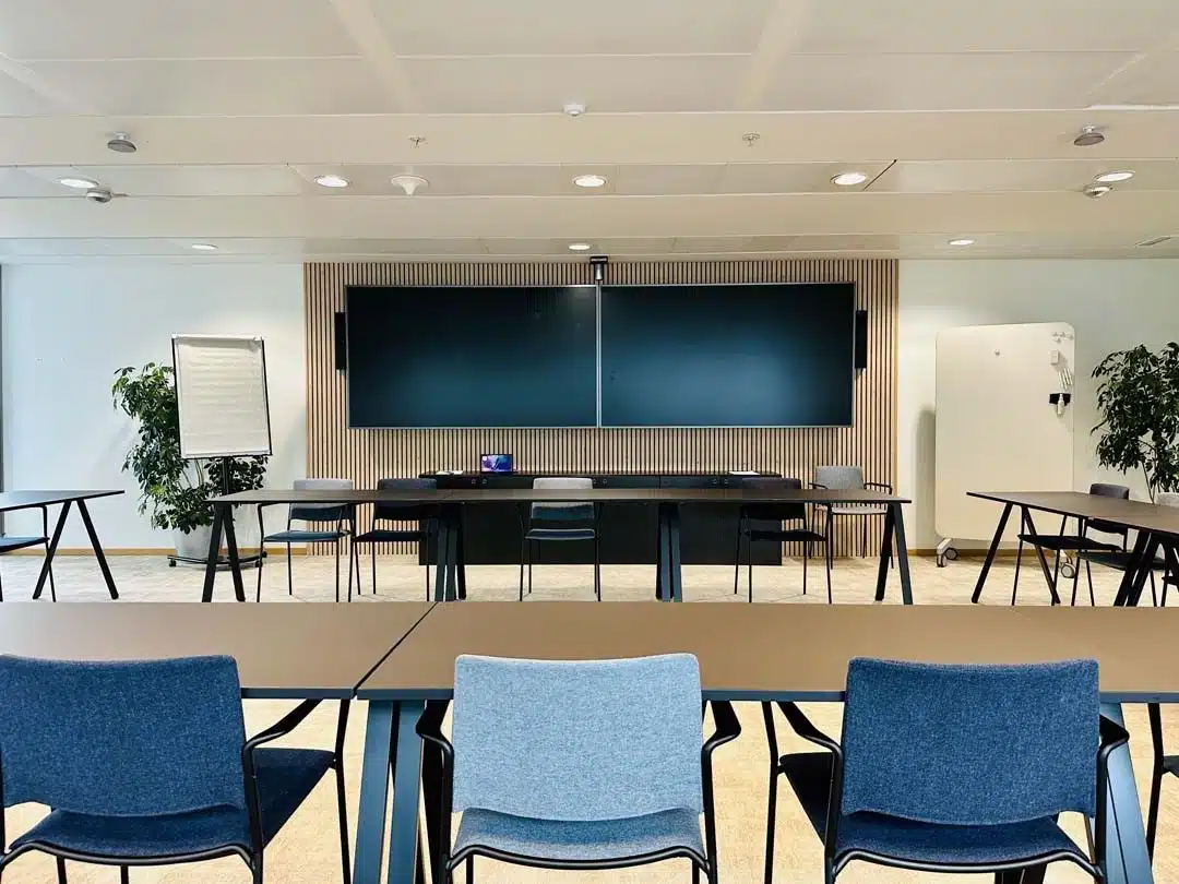 Moderne vergaderzaal met akoestische wandbekleding en flexibel meubilair voor een industriële kantooromgeving