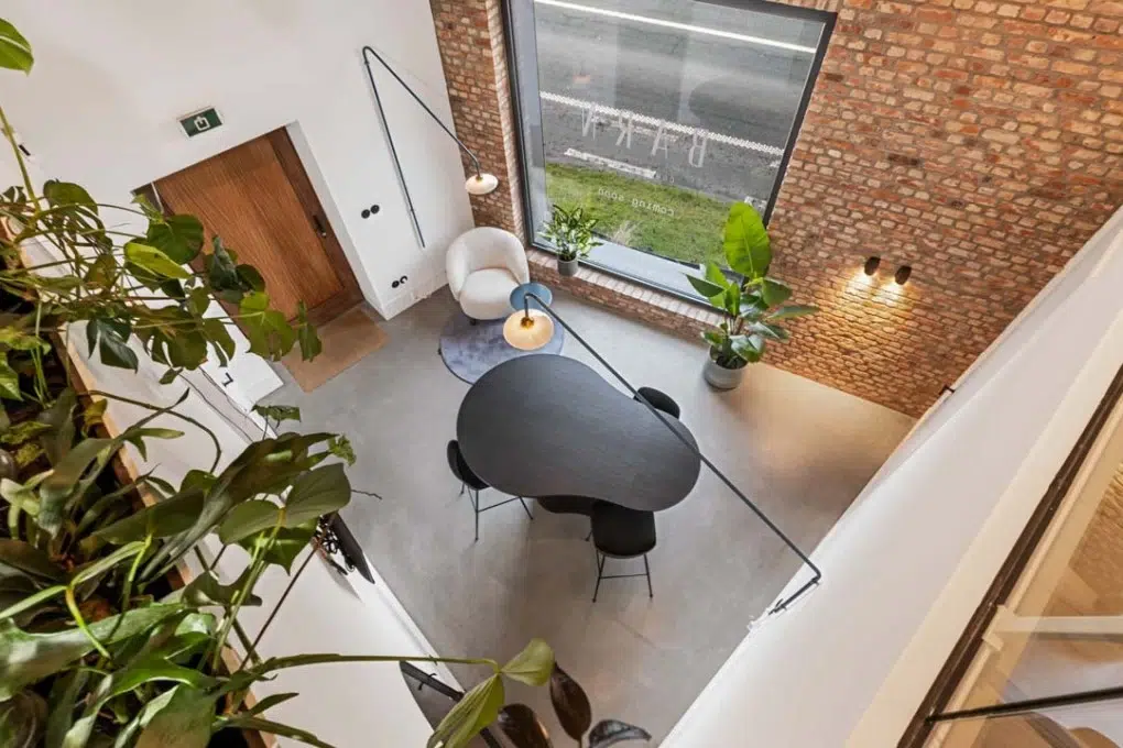 Zithoek met ronde tafel en veel daglicht in de coworkingruimte van Barn Coworking