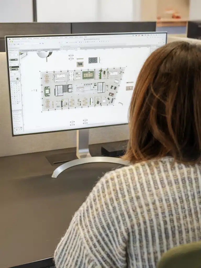 Ontwerper werkt aan de indeling en ruimtelijke planning van een kantoorrenovatie op computer