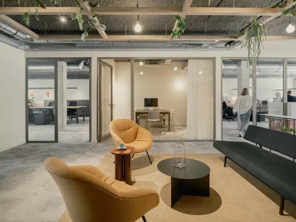 Gezellige zithoek in een modern kantoor met open indeling en glazen wanden en zones