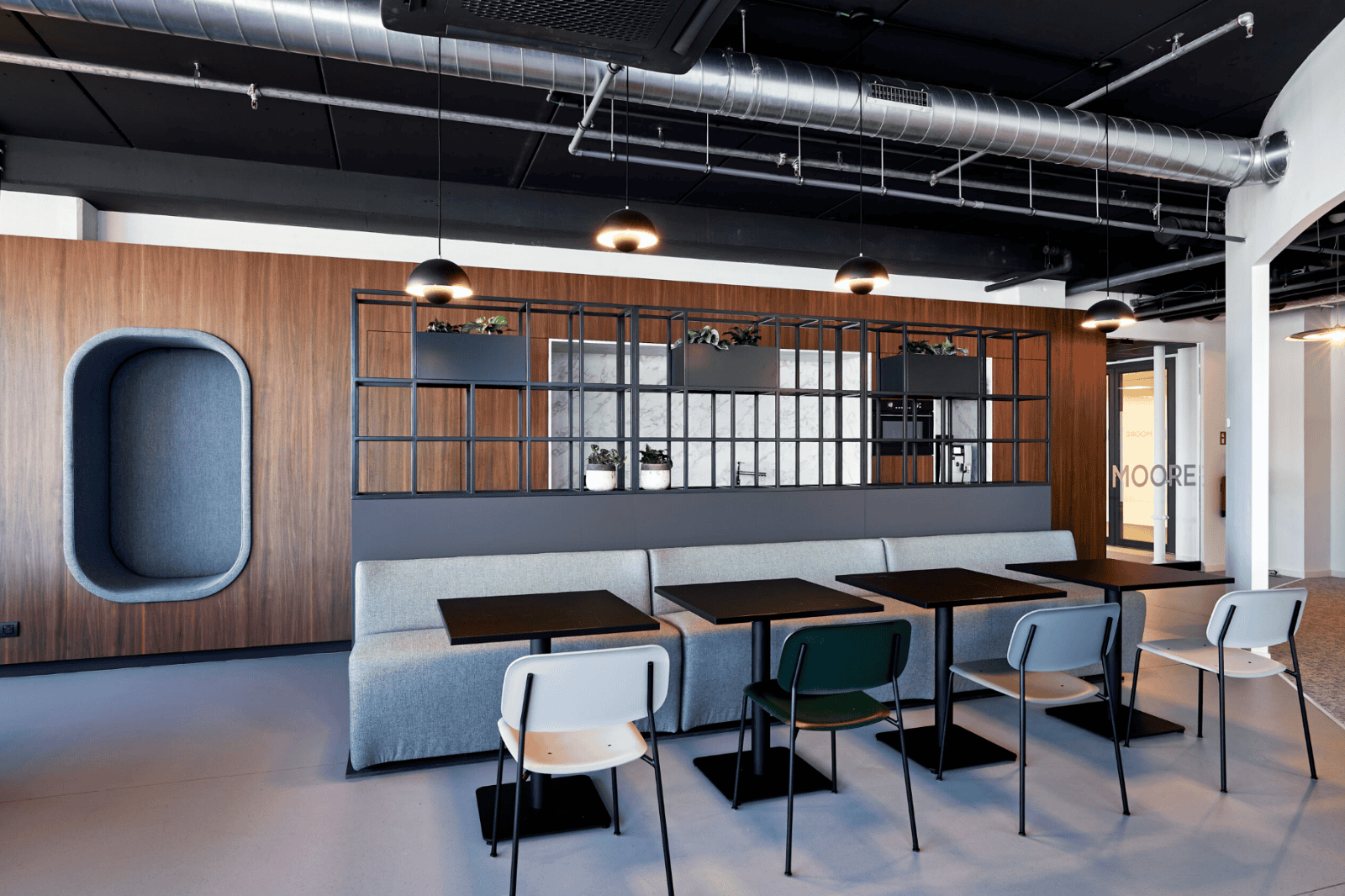 Moderne kantine met houten wand en industriële verlichting