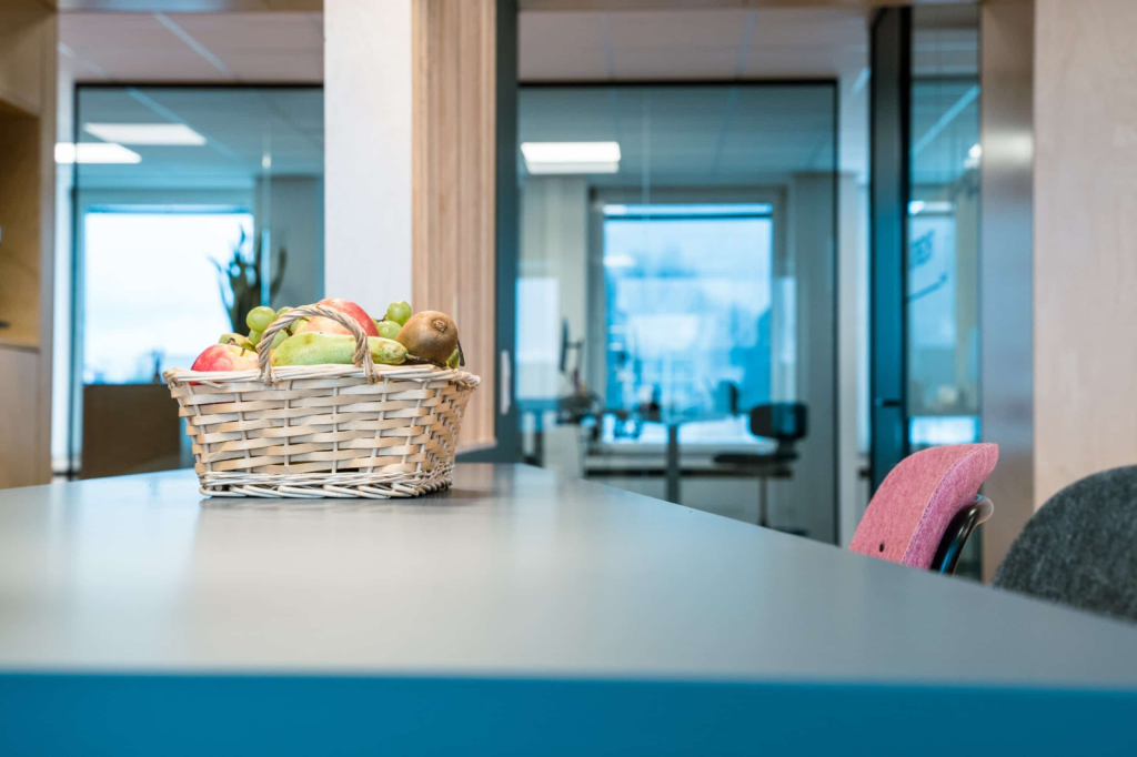 Moderne kantoorruimte met een fruitschaal op de tafel, ontworpen om rust, professionaliteit en flexibiliteit te ondersteunen
