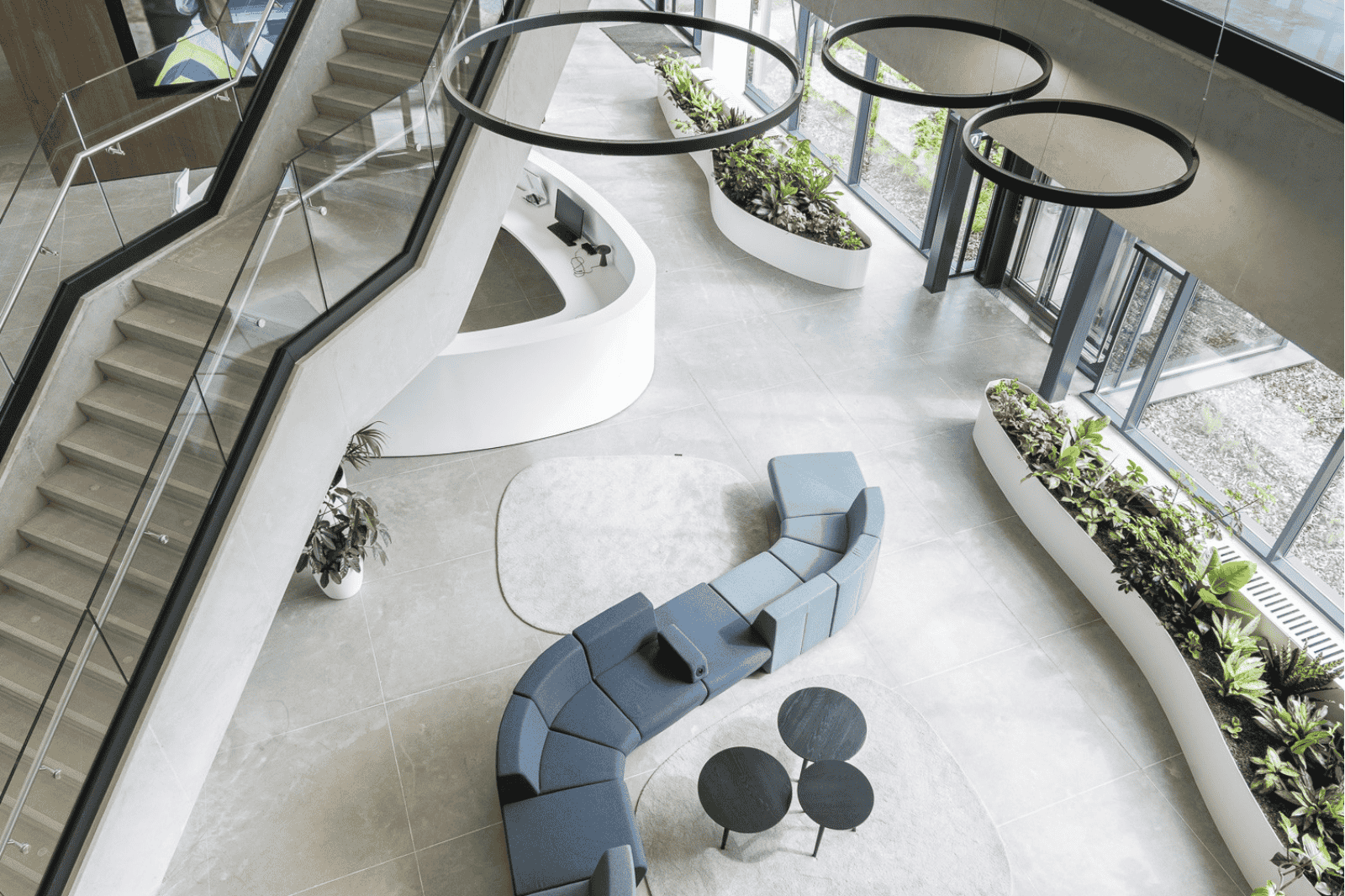 Kantoorinrichting door Buro Project met een lichte ontvangstruimte met trap, grote raampartijen, groen en lounge-opstelling.
