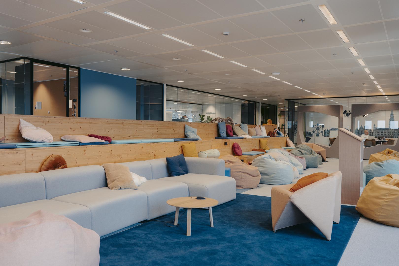 Open kantoorzone met informele zitplekken en spelelementen die samenwerking en creatief denken stimuleren