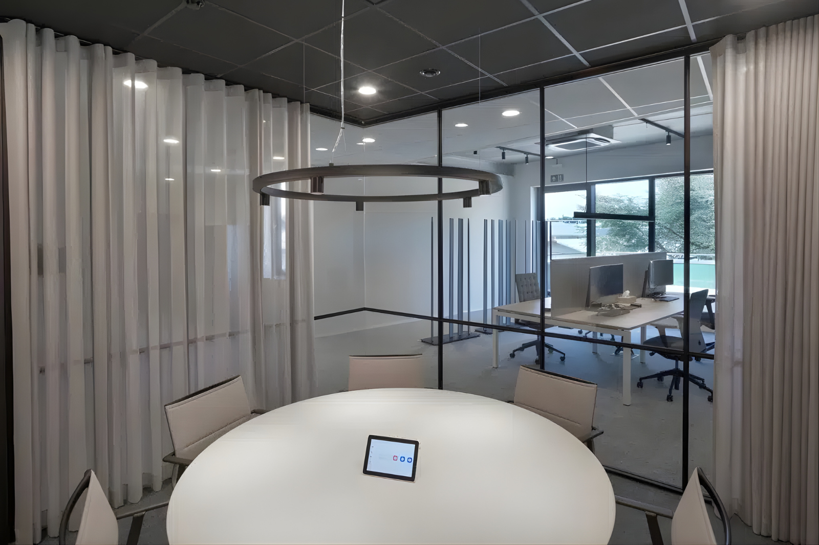 Slim ingedeelde vergaderruimte in een farmaceutisch kantoor die duidelijke zonering creëert tussen overleg en geconcentreerd werken