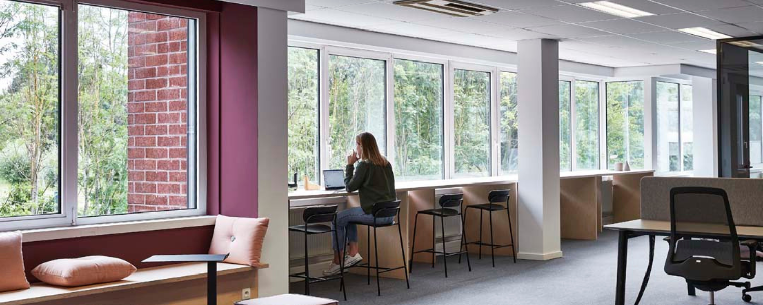 Flexibele werkplek aan het raam met hoge tafels voor geconcentreerd werken in een lichte ruimte