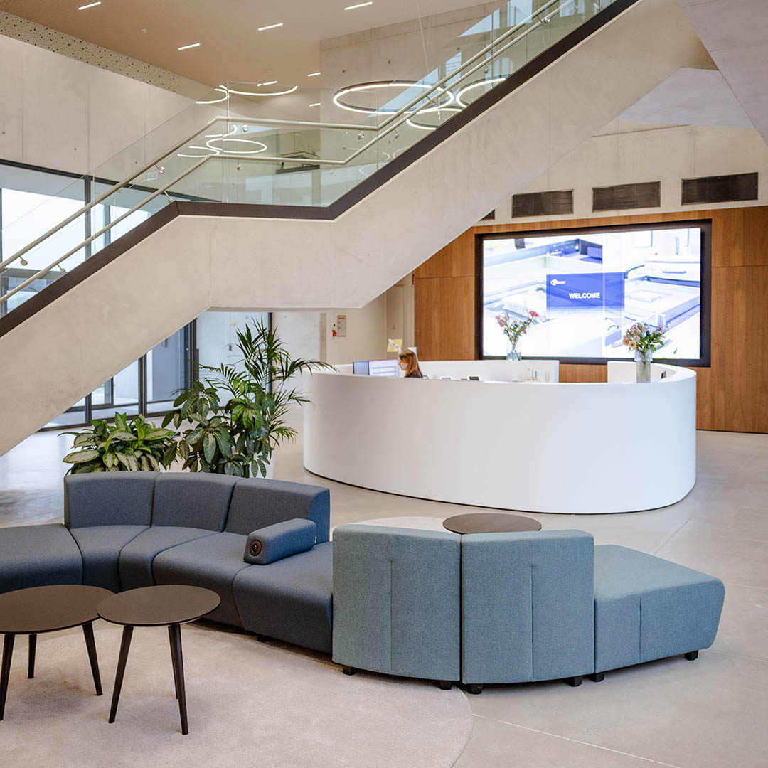 Stijlvolle kantoorinrichting met moderne receptiebalie, designmeubilair en open ontvangstruimte voor bezoekers.