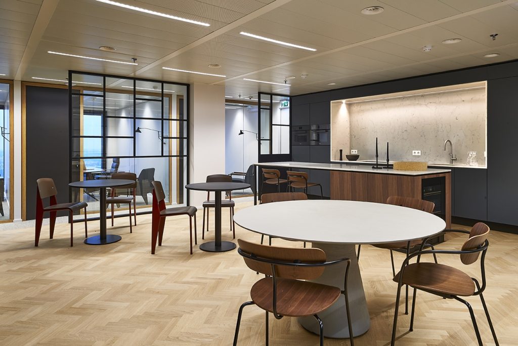 Stijlvolle vergaderruimte met kwalitatief kantoormeubilair en moderne keukenhoek.