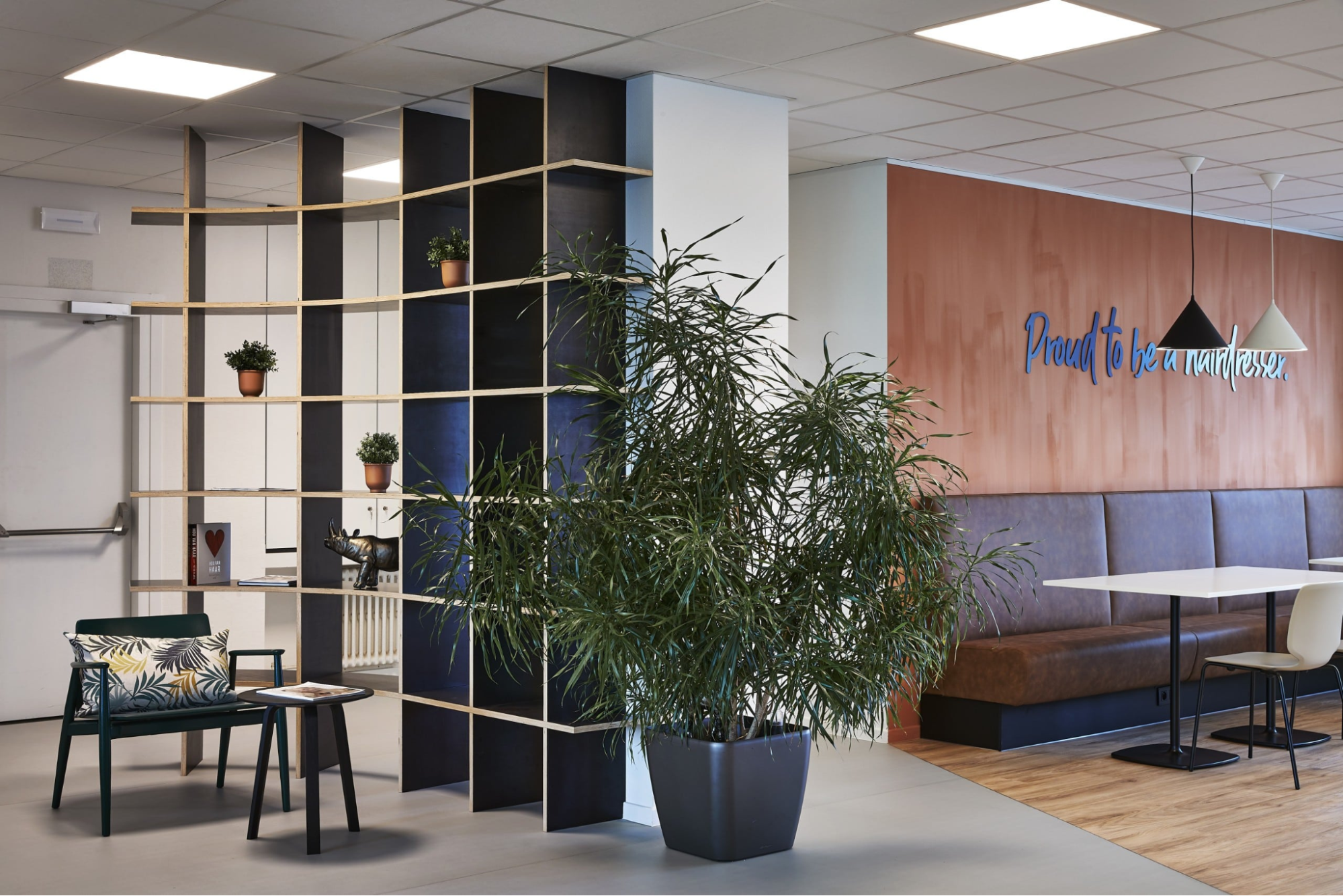 Kantoorinrichting met planten en warme materialen die zorgen voor een aangename en ontspannen werkomgeving.