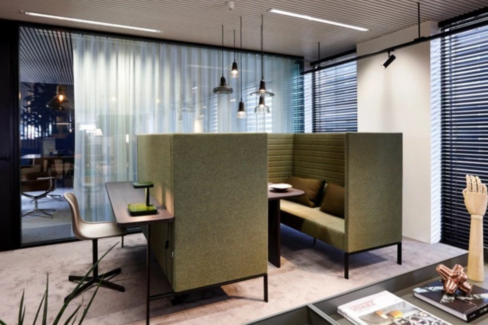 Akoestische werkbooths in zacht bekleed materiaal zorgen voor geluidsabsorptie en concentratie in een open kantooromgeving.