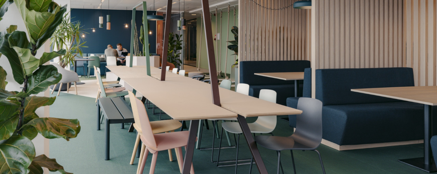 Kantoorontwerp in zones met lange werktafel, akoestische zithoeken en groen in de werkplek van de toekomst