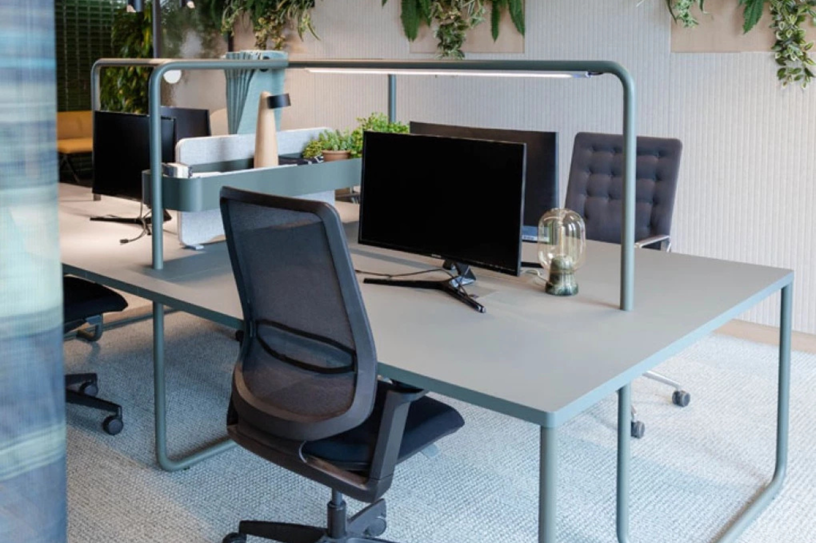 Een ergonomische bureaustoel aan een werkplek met een correct opgesteld beeldscherm op ooghoogte.
