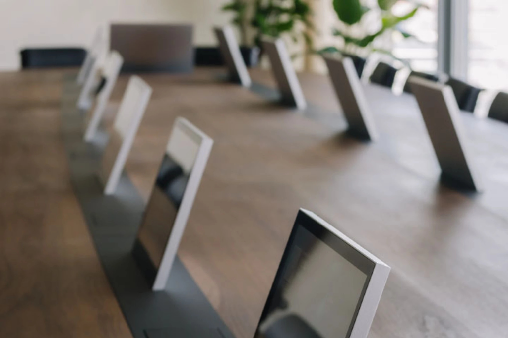 Rij tafelmicrofoons op een vergadertafel als onderdeel van de AV-uitrusting.
