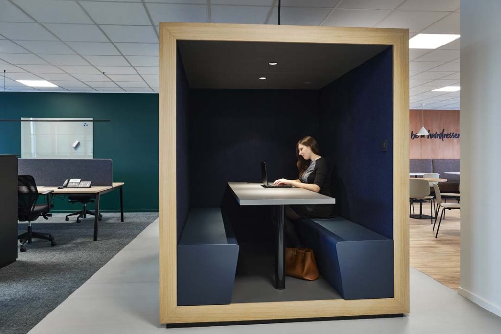 Akoestische belcel in houten frame biedt rust voor een geconcentreerd videogesprek